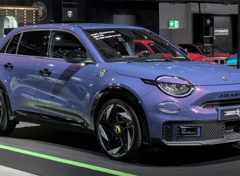 Abarth 600e in Farbe Hypnotic Purple, Seitenansicht, im Showroom
